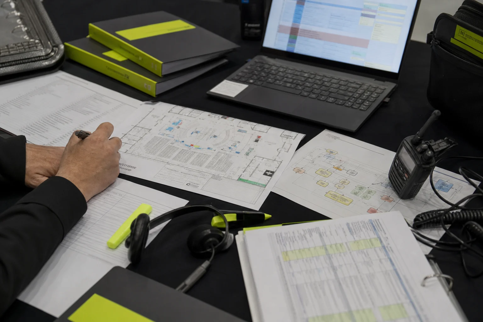 Mesa de preproduccion con escaleta, plano de sala y documentacion tecnica para un evento